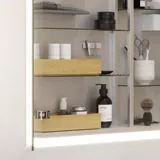 Lille badeværelse inspiration med lille vaskeskab i specialfarve med integreret greb, spejlskab med lamper, dekorationsspejl med tonet glashylde, hvide sildebensfliser på væggen giver et stilrent og klassisk udtryk.