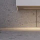 Badeværelse med skrå loft inspiration, beige badeværelsesmøbler med rifler, elegant bordplade samt firkantet bordstående håndvask, smukt firkantet spejl med stilfulde hylder, blå vægge, store vinduer og sort sildebensgulv giver et lyst og urban udtryk.