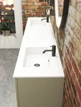 Råt og moderne badeværelse i urban stil. Flotte vaskeskabe og runde spejle med sort kant