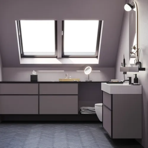 Badeværelse med skrå vægge inspiration, med badeværelsesmøbler i lilla med elegante rammefronter, flot ovalt spejl med lampe, smuk og praktisk hylde, samt lillamalet væg og gråt sildebensgulv, der giver et elegant og moderne udtryk.
