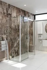 Badeværelse inspiration med luksuriøs brusekabine med skydedør, hvide badeværelsesmøbler samt væg i råt look, der giver badeværelset et rå og urban udtryk