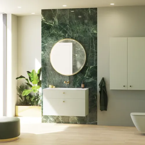 Stilfuldt og luksuriøst badeværelse med blide grønne nuancer, et stort elegant rundt spejl og et moderne, sofistikeret grønt toilet