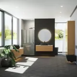 Minimalistisk og stilrent badeværelse inspiration med vaskeskab, underskabe og højskabe i gylden eg, stort rundt spejl med lysstyring, farvet toilet og bordstående håndvask