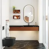 Moderne og stilfuld badeværelse inspiration med oval spejl med sort ramme og lysstyring, farvet toilet, vaskeskab, underskabe og skabe i rødbrun eg, Silestone vask og matchende gulv