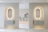Stilfuld og moderne badeværelse inspiration med ovale spejle med lysstyring, stenvaske og vaskeskabe med fine og elegante riller i et minimalistisk design, badeværelset har en lys og luftig atmosfære med elegant belysning og raffinerede detaljer