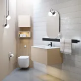 Stilfuld badeværelse inspiration med beige vaskeskab med inderskuffe, overskab, åben reol, oval spejl med belysning, matchende pendler, hylde under spejlet, og væghængt toilet. Vægge med lyse, aflange fliser