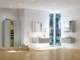 Stort badeværelse inspiration i nordisk stil med badeværelsesmøbler i lys blå farve og træbordplade med elegant bordstående håndvask, sildebensgulv i træ, der skaber en lys og klassisk stil