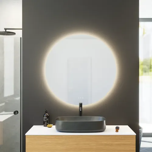 Minimalistisk og stilrent badeværelse inspiration med vaskeskab, underskabe og højskabe i gylden eg, stort rundt spejl med lysstyring, farvet toilet og bordstående håndvask