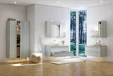 Stort badeværelse inspiration i nordisk stil med badeværelsesmøbler i lys blå farve med integreret greb, og træbordplade med elegant bordstående håndvask, sildebensgulv i træ, der skaber en lys og klassisk stil.