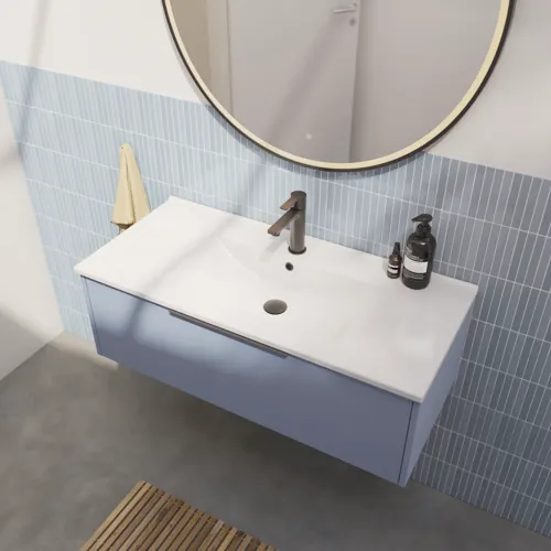 Badeværelse inspiration med aflange lyseblå fliser og betongulv, elegant vaskeskab i lys blå og smukke smalle striber, stilren og tynd håndvask, samt minimalistisk rundt spejl med sort kant og lys, der giver et strejf af elegance til dit badeværelse.