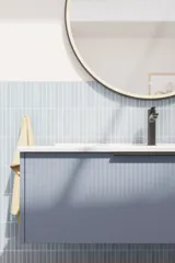 Badeværelse inspiration med aflange lyseblå fliser og betongulv, elegant vaskeskab i lys blå og smukke smalle striber, stilren og tynd håndvask, samt minimalistisk rundt spejl med sort kant og lys, der giver et strejf af elegance til dit badeværelse.