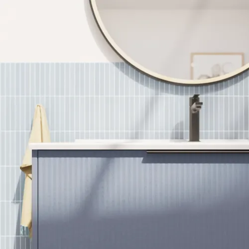 Badeværelse inspiration med aflange lyseblå fliser og betongulv, elegant vaskeskab i lys blå og smukke smalle striber, stilren og tynd håndvask, samt minimalistisk rundt spejl med sort kant og lys, der giver et strejf af elegance til dit badeværelse.