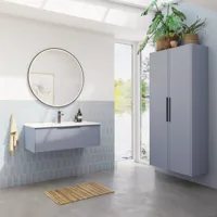 Badeværelse inspiration med aflange lyseblå fliser og betongulv, elegant vaskeskab i lys blå og smukke smalle striber, stilren og tynd håndvask, dobbelt højskab med smukke smalle striber, samt minimalistisk rundt spejl med sort kant og lys.