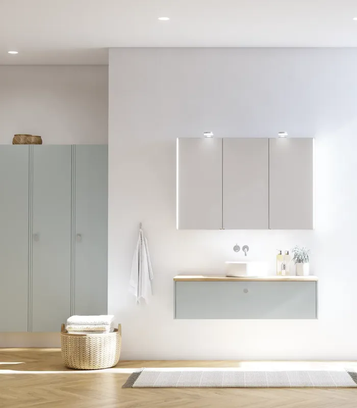 Stort badeværelse inspiration i nordisk stil med badeværelsesmøbler i lys blå farve og træbordplade med elegant bordstående håndvask, sildebensgulv i træ, der skaber en lys og klassisk stil