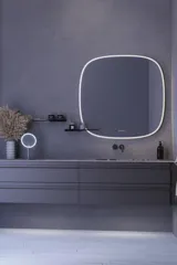 Stort badeværelse inspiration med grå vaskeskab med integreret greb, stilfuld sidestillet håndvask, firkantet spejl med afrundede hjørner, vægge i beton look samt rå materialer giver et urban udtryk