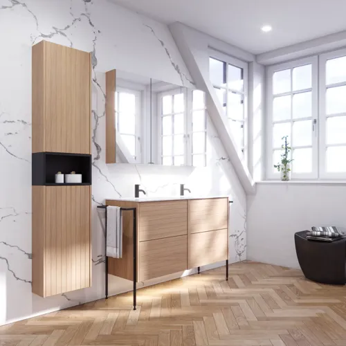 Badeværelse inspiration med vaskeskabe samt overskabe i lys eg med lameller, elegant dobbelt håndvask, smukt spejlskab med lys, sildebensgulv i lys træ og hvid marmorvæg giver et klassisk, lyst og stilrent udtryk.