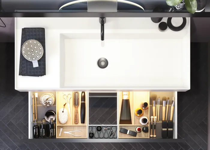 Badeværelse med skrå vægge inspiration, med badeværelsesmøbler i lilla med elegante rammefronter, flot ovalt spejl med lampe, smuk og praktisk hylde, samt lillamalet væg og gråt sildebensgulv, der giver et elegant og moderne udtryk.